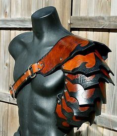 a mannequin wearing a leather armor with orange flames on it's chest