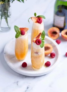 three glasses filled with champagne and topped with raspberries