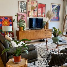 a living room filled with furniture and lots of pictures on the wall above it's tv