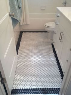 a bathroom with black and white floor tiles