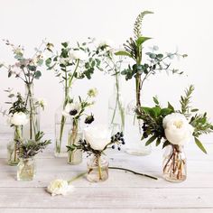 several vases with flowers in them sitting on a table