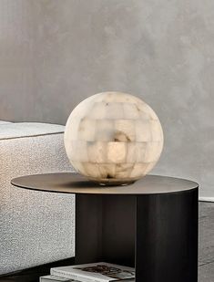 a white ball sitting on top of a table next to a couch