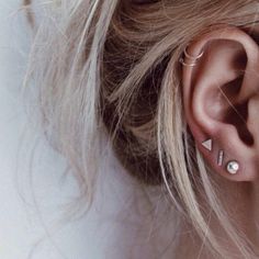 a woman's ear with two piercings on it