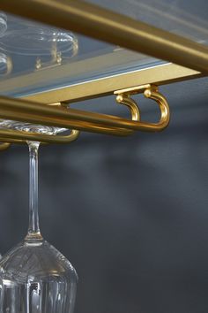 a wine glass is hanging from a gold bar