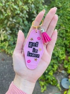 a pink keychain with the words get in closer written on it and stars