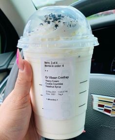 a person holding up a cup of ice cream in their hand with the label on it