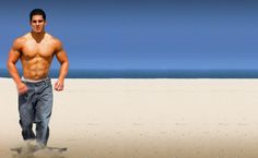 a shirtless man running on the beach