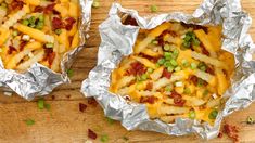 french fries covered in cheese and peas on top of tin foil with ketchup