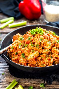 a bowl filled with rice and vegetables on top of a wooden table