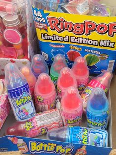 a box filled with lots of pink and blue bottles next to other items in it