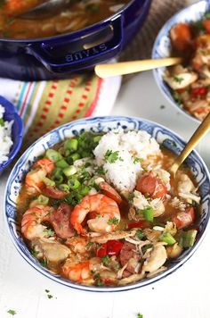 two bowls filled with shrimp and rice on top of a white table next to a blue pot