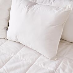 two white pillows sitting on top of a bed