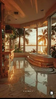 an indoor jacuzzi tub in the middle of a room with large windows and palm trees