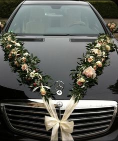 a car decorated with flowers and ribbons for the bride's wedding day is shown