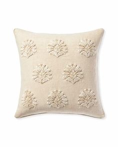 a white pillow with embroidered flowers on it