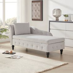 a white chaise lounger sitting on top of a rug in a living room