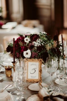 the table is set with wine glasses, plates and place cards for guests to sit at