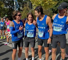 a group of men standing next to each other in front of a cross country finish line