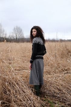 a woman standing in the middle of a field