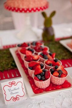 there are many cups with strawberries and blueberries in them on the trays