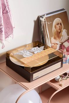 a pink desk with an album and magazine on it