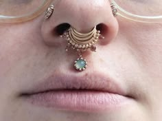 a close up of a woman's nose and nose piercing