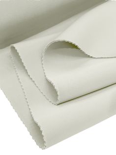 white sheets with scalloped edges folded on top of each other in an angled position