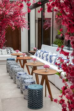 an outdoor seating area with blue and white vases on the tables next to each other