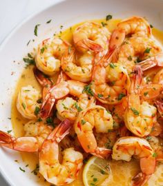 a white bowl filled with shrimp and lemon