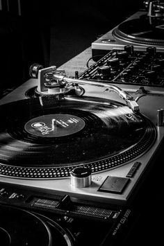 two turntables are sitting next to each other in black and white, one has a record player on it