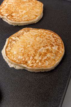 two pancakes sitting on top of a black pan