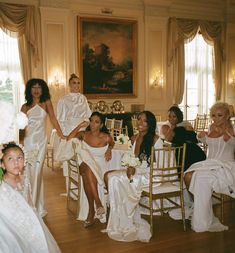 a group of women sitting around each other at a wedding