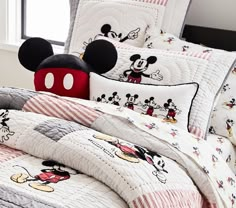 a mickey mouse bed set with red and white striped pillow cases on top of it