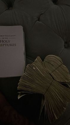 a book sitting on top of a couch next to a pile of books