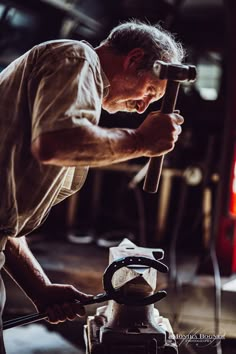 an older man working on something with a hammer