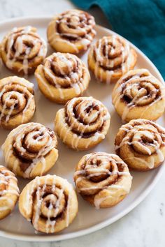 a white plate topped with cinnamon rolls covered in icing