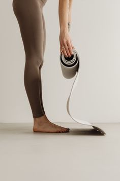 a woman with her leg in the air while holding a hair dryer