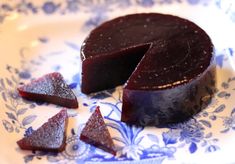 a piece of chocolate cake on a blue and white plate next to pieces of red velvet