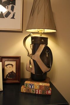 a lamp that is sitting on top of a table next to a bag and some books