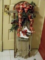 a christmas decoration on top of a wooden sled in front of a red door