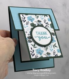 a hand holding up a thank you card