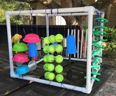 tennis balls and rackets are displayed on a wooden table in front of a tree