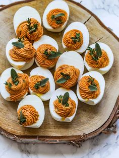 deviled eggs with carrots and herbs on a wooden platter, ready to be eaten