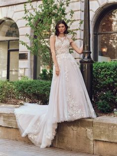 a woman in a wedding dress leaning against a lamp post