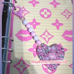 a pink and white heart shaped beaded necklace on a notepad with clippings