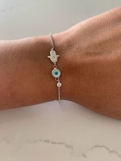 Evil Eye Hamsa Bracelet in Sterling Silver, Evil Eye, Hamsa, Bracelet, Guardian Angel Bracelet, Sterling Silver Bracelet, Hamsa Bracelet ----------------------------------------------- ♦ ------------------------------------------------- Great bracelet for everyday wear. It is rhodium over silver, a strong material to help your jewelry looking great for a long period of time - wear it in the shower and it won't tarnish. The Silver Eye Bracelet with Cross comes at a great affordable price and make White Sterling Silver Friendship Bracelets, Handmade White Charm Bracelet In Sterling Silver, White Bohemian Bracelet With Adjustable Chain, Handmade White Sterling Silver Charm Bracelet, Handmade Silver Evil Eye Bracelet For Friendship, Adjustable Evil Eye Chain Bracelet Gift, White Adjustable Symbolic Bracelets, Adjustable Symbolic White Bracelet, Adjustable White Symbolic Bracelets