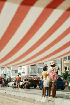 two people are standing on the edge of a wall with an american flag in the background