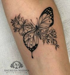 a black and white butterfly with flowers on its wings is shown in this tattoo design