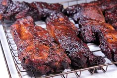 several pieces of meat sitting on top of a metal rack