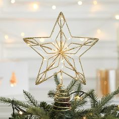 a star ornament on top of a christmas tree